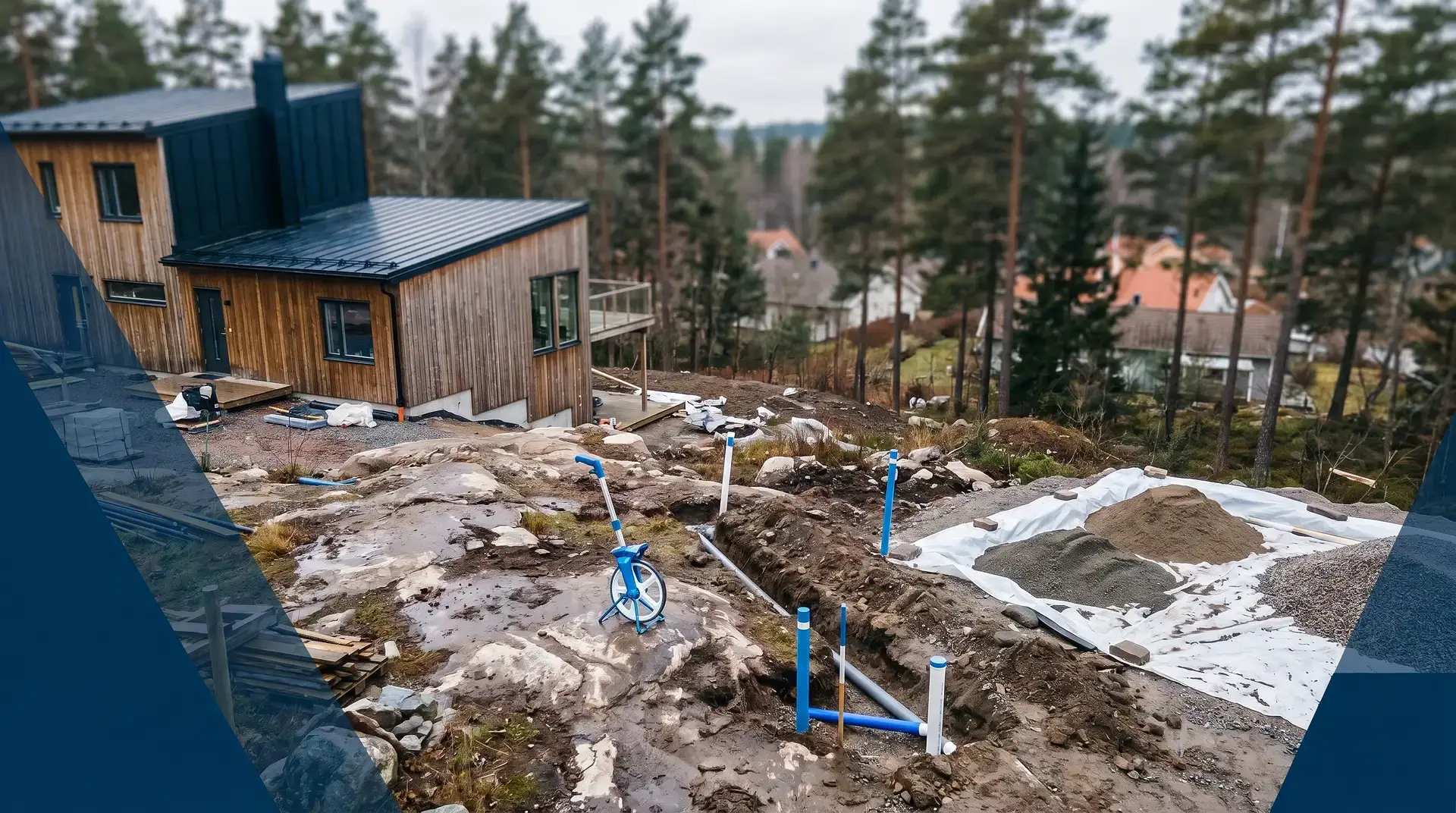 Nybyggd trähusfasad med pågående markarbeten och VA-rör i förgrunden.